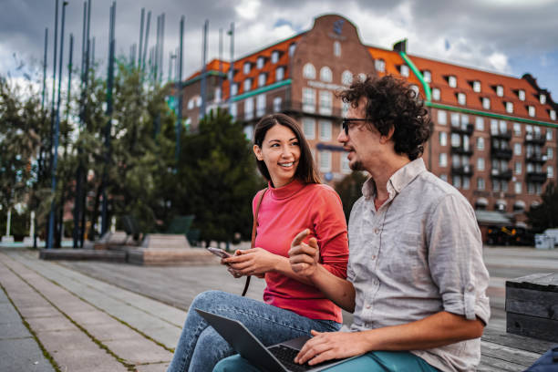 istock Young colleagues working remotely in Malmo, Sweden, using laptop and smartphone 2198968417