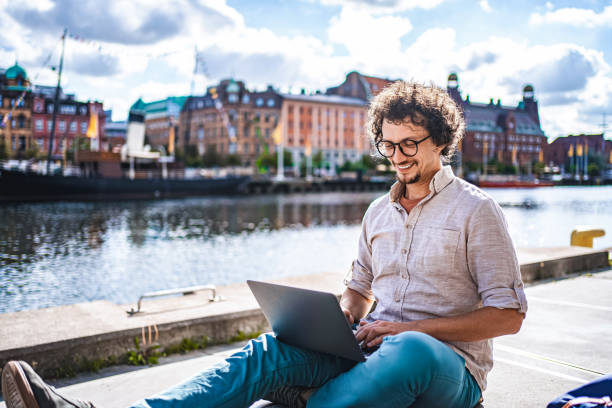 istock Young Man Working Remotely with Laptop in Malmo, Sweden 2198968419