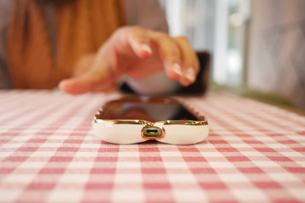 man hand picking up smart phone mobile from a table