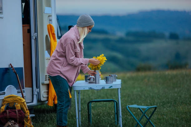 istock Young Woman Preparing Breakfast Table in Front of Camper Van 2198971200