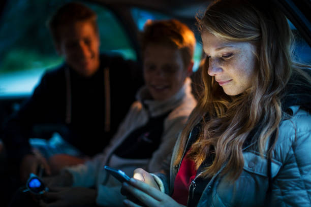 istock Young siblings kids watching mobile phone in a car 2198971852