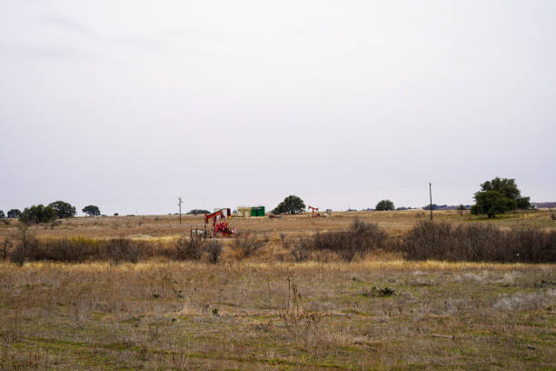 istock Grassy Field With Red Oil Pump and Cloudy Sky 2198972564
