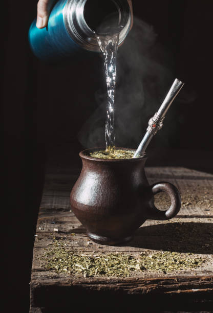 istock Water served in a steaming infusion of yerba mate on a rustic table with black background. 2198972683