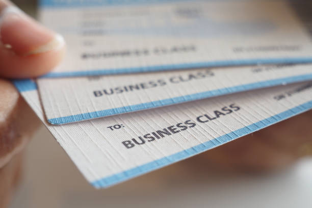 A detailed closeup view showcasing multiple business class flight tickets being held by a hand