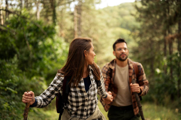 istock Young couple walking through the forrest and exploring nature 2198976132