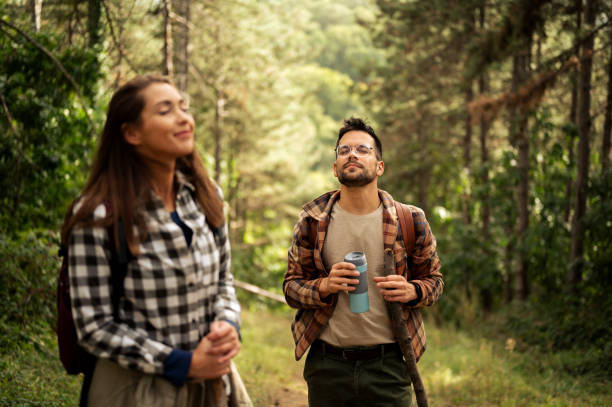 istock Young couple walking through the forrest and exploring nature 2198976143