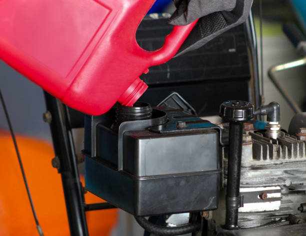 istock person pouring gas into a snow blower tank from a red container 2198976585