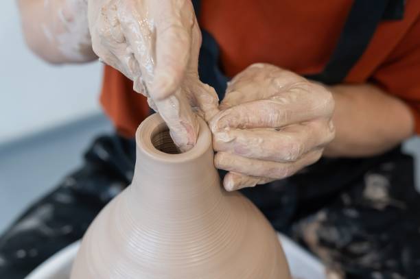 istock Close-up of a potter's hands making a ceramic vase on a potter's wheel. 2198977002