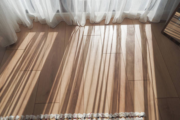istock Sunlight on the wooden floor with sheer curtains creates a serene, inviting atmosphere 2198977745