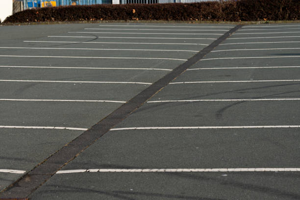 istock Parking lot with empty spaces and clear lines during daylight 2198980728
