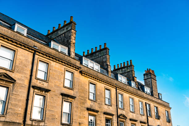 istock Rooftops and chimneys rising under a blue sky in bath, england 2198984117