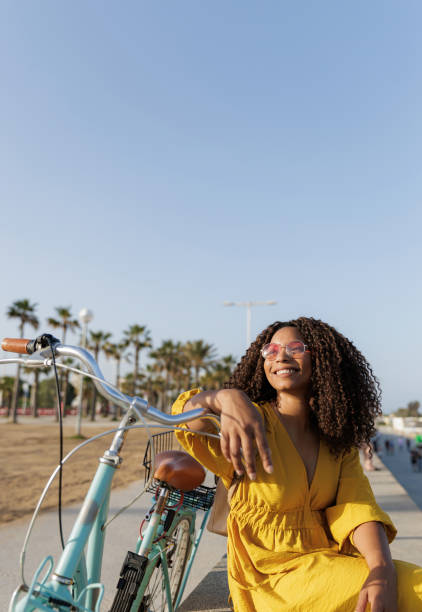 istock Young woman relaxing with her bicycle on a sunny day at beach 2198984506
