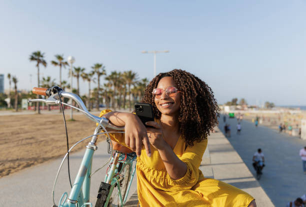 istock Tourist using smartphone app on the beach next to her bicycle, enjoying summer holidays 2198984526