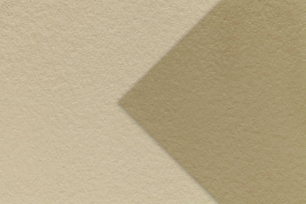 istock Texture beige paper background, half two colors with brown arrow, macro. Structure dense craft sand cardboard. 2198984988