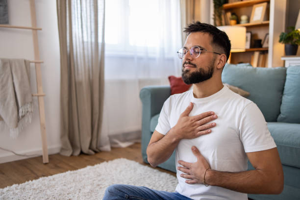 Young man meditating at home