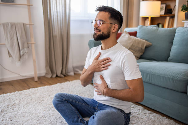 istock Young man meditating at home 2198987536