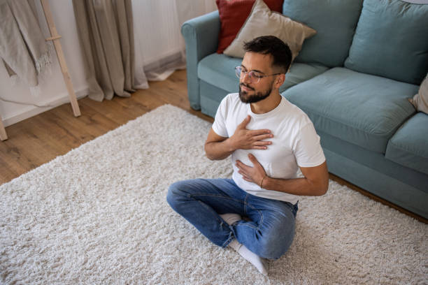 istock Young man meditating at home 2198987550
