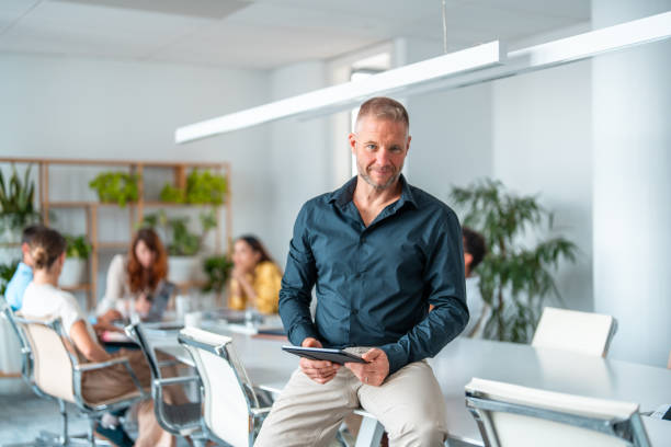 istock Mid Adult Caucasian Businessman Using Tablet in Boardroom 2198990196
