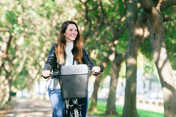 Woman riding bicycle in park enjoying sunny day