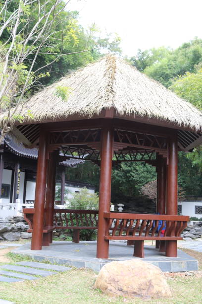 istock A wooden pavilion with a thatched roof sits in a park 2199000367