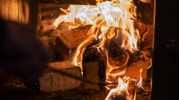 istock Eco-friendly compressed wood briquettes ignite a warm, inviting fire in a modern stove, showcasing sustainable heating and cozy ambiance for any home 2199000370