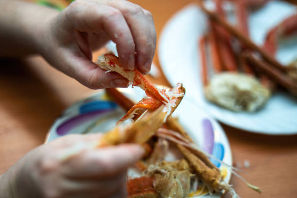 istock hand reaches into a segment of a boiled crab, pulling out a large piece of succulent crab meat, showcasing the delicious seafood delicacy 2199005424