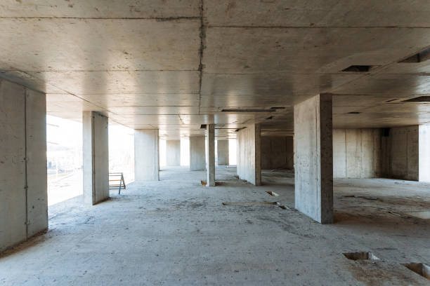 istock A large, spacious empty room featuring unfinished concrete walls and sturdy pillars, all situated within a building that is currently under construction and is not yet complete 2199005777