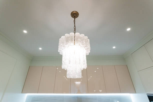 istock A beautiful chandelier is elegantly hanging from the ceiling in a cozy kitchen, serving as a stunning light fixture that enhances the overall interior design and ambience of the space 2199005850