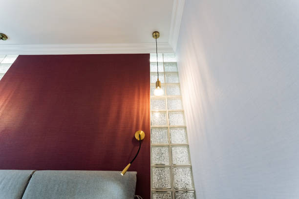 istock The living room features a striking red wall that serves as an eyecatching backdrop, accompanied by a comfortable couch and a stylish lamp that enhances the rooms aesthetic appeal 2199005852