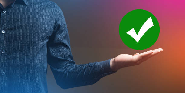istock man holding a check mark icon in his hand 2199007866