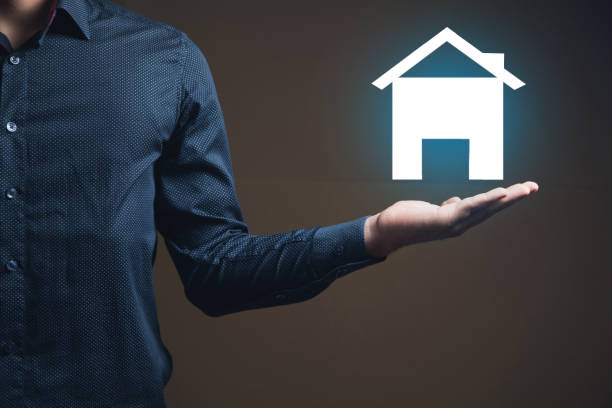 istock a man holding a house icon in his hand 2199007873