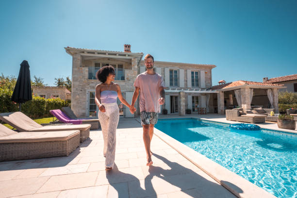 istock Mixed Race Couple Holding Hands by the Pool 2199010523