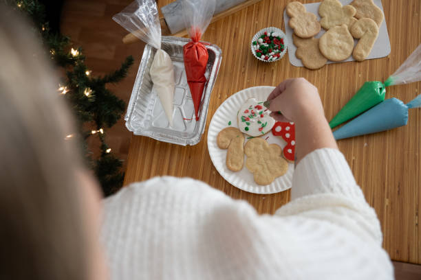 istock Woman decorating Christmas cookies with icing and festive sprinkles 2199014897