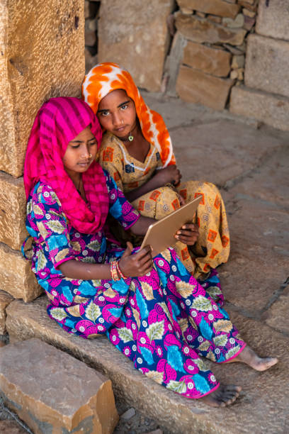 istock Happy Gypsy Indian girls using a digital tablet, India 2199024105