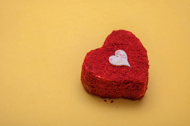 istock Heart-Shaped red velvet cake on yellow background. 2199025370