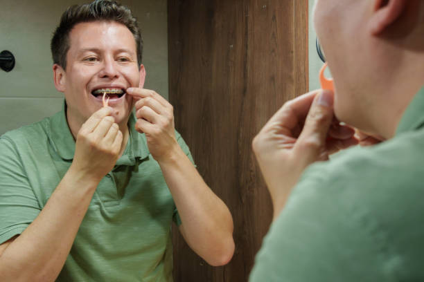 istock Man Preparing Dental Floss in Front of Bathroom Mirror 2199030058
