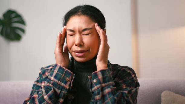 istock Young Hispanic woman massages temples coping with migraine 2199030780