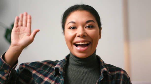 istock Positive Hispanic woman waves hand talking on video chat 2199030783