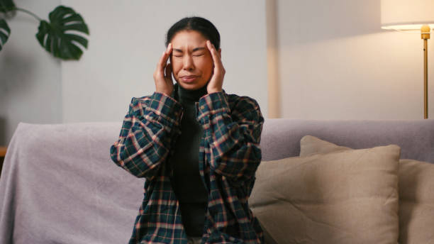 istock Young Hispanic woman massages temples coping with migraine 2199030800