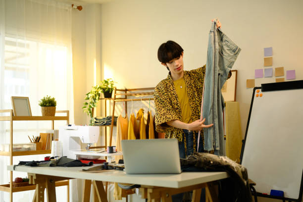istock Creative fashion designer inspecting a pair of denim jeans in a creative studio 2199031970