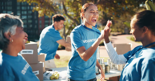 istock High five, volunteer and charity in teamwork for community service, project or nonprofit initiative. People, happiness and together with collaboration, outdoor and program for help, donations and NGO 2199033995