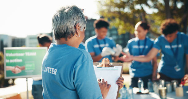 istock Checklist, volunteer and program as group for community service, project or nonprofit initiative. Female person, clipboard and notes for sustainability, outdoor or charity with help, donations or NGO 2199034007