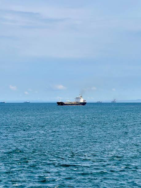 istock Cargo Ship Sailing in Bali Strait on a Clear Blue Ocean with Distant Vessels and Horizon Under a Bright Sky for Maritime Trade, Global Shipping, Transportation, and Logistics 2199034670