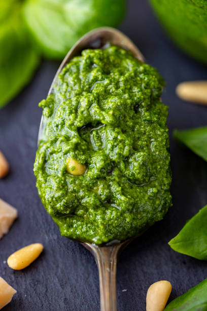 Homemade Basil Pesto Sauce on a Spoon with Ingredients