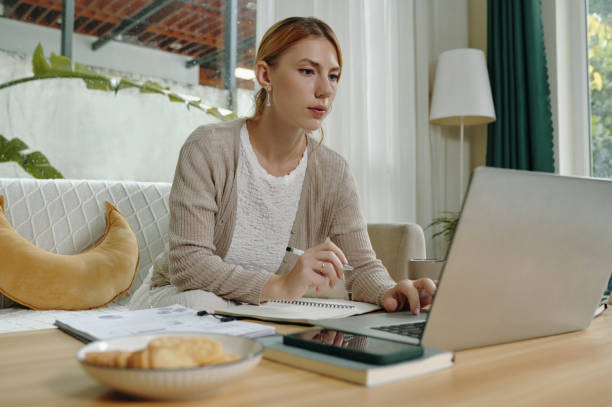 istock Working Remotely at Home with Laptop in Modern Living Room 2199040813