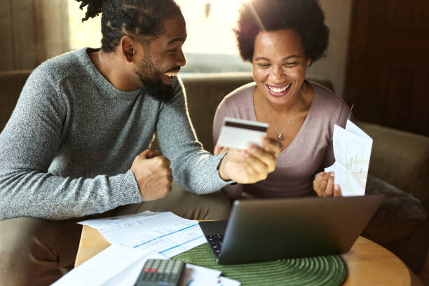 istock Cheerful black couple paying their bills online at home. 2199040854