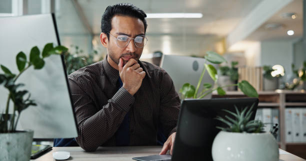 istock Thinking, research and Asian man in office with laptop for proofreading, creative agency or self publishing. Online, story or entrepreneur with ideas, technology and editing of ebook novel for review 2199045680