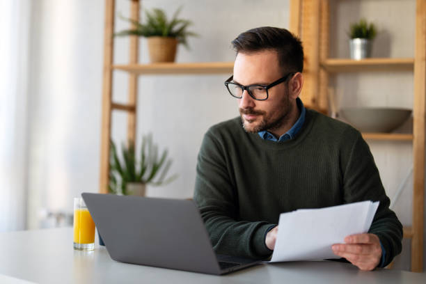 istock Business man accountant analyst holding documents, work at laptop computer doing online trade market 2199046334