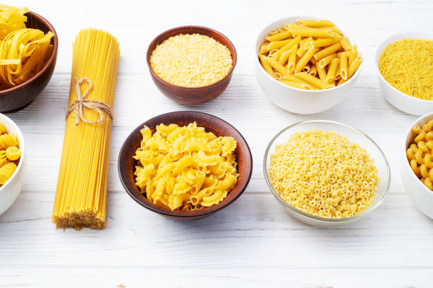 Assorted Uncooked Pasta in Bowls on Wooden Table