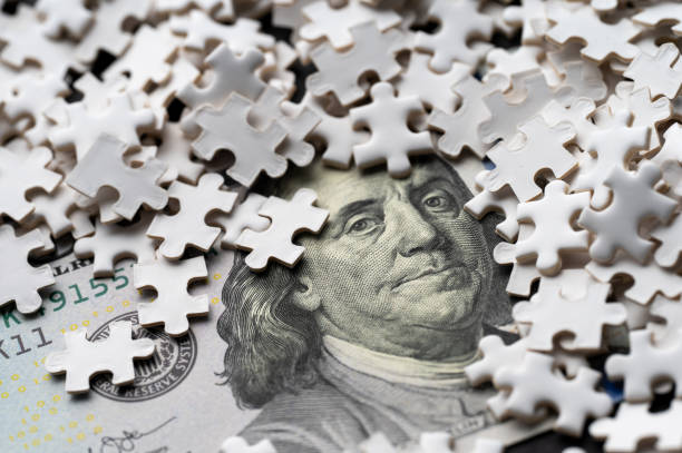 istock Benjamin Franklin's portrait on a hundred-dollar bill partially covered by puzzle pieces 2199052201